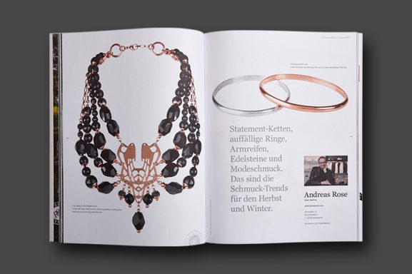 Referenz Schmuckfotografie für Magazine & PR – Collier und Armreifen Magazin-Doppelseite mit freigestelltem schwarzem Edelstein-Collier in Roségold sowie glänzenden Armreifen in Silber und Roségold.